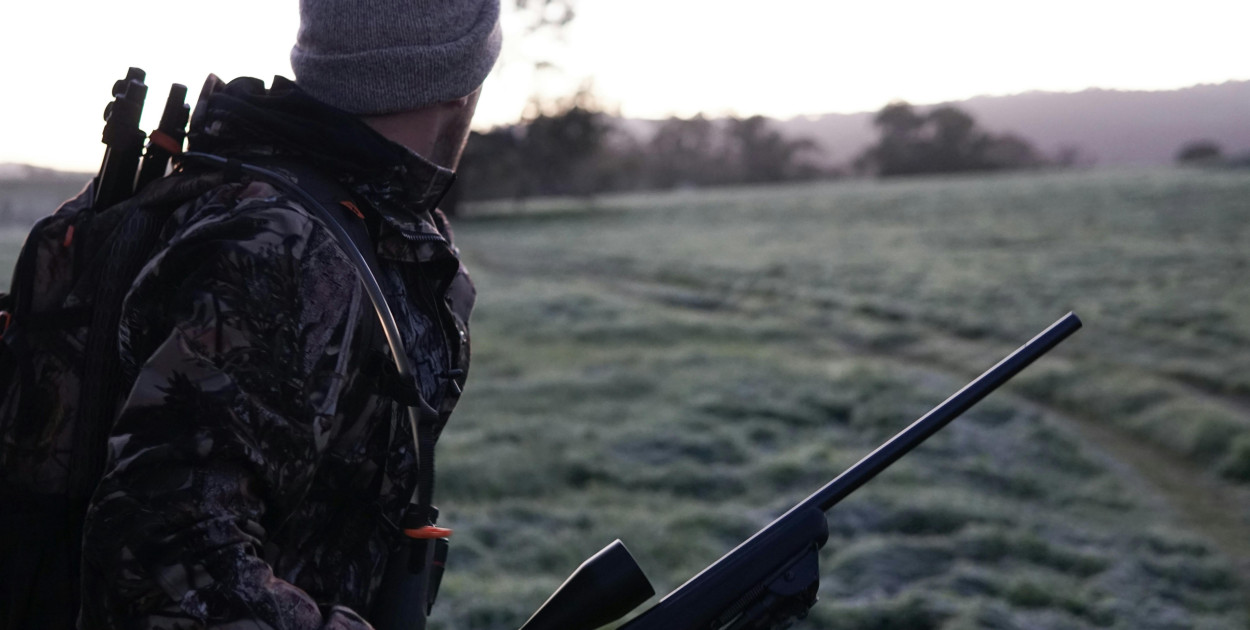 Zdjęcie dodane przez Elle Hughes: https://www.pexels.com/pl-pl/zdjecie/mezczyzna-ubrany-w-szaro-czarna-kurtke-kamuflaz-gospodarstwa-karabin-chodzenie-po-polu-trawy-2954926/